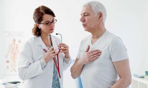 Physician attending to patient with hand on his heart